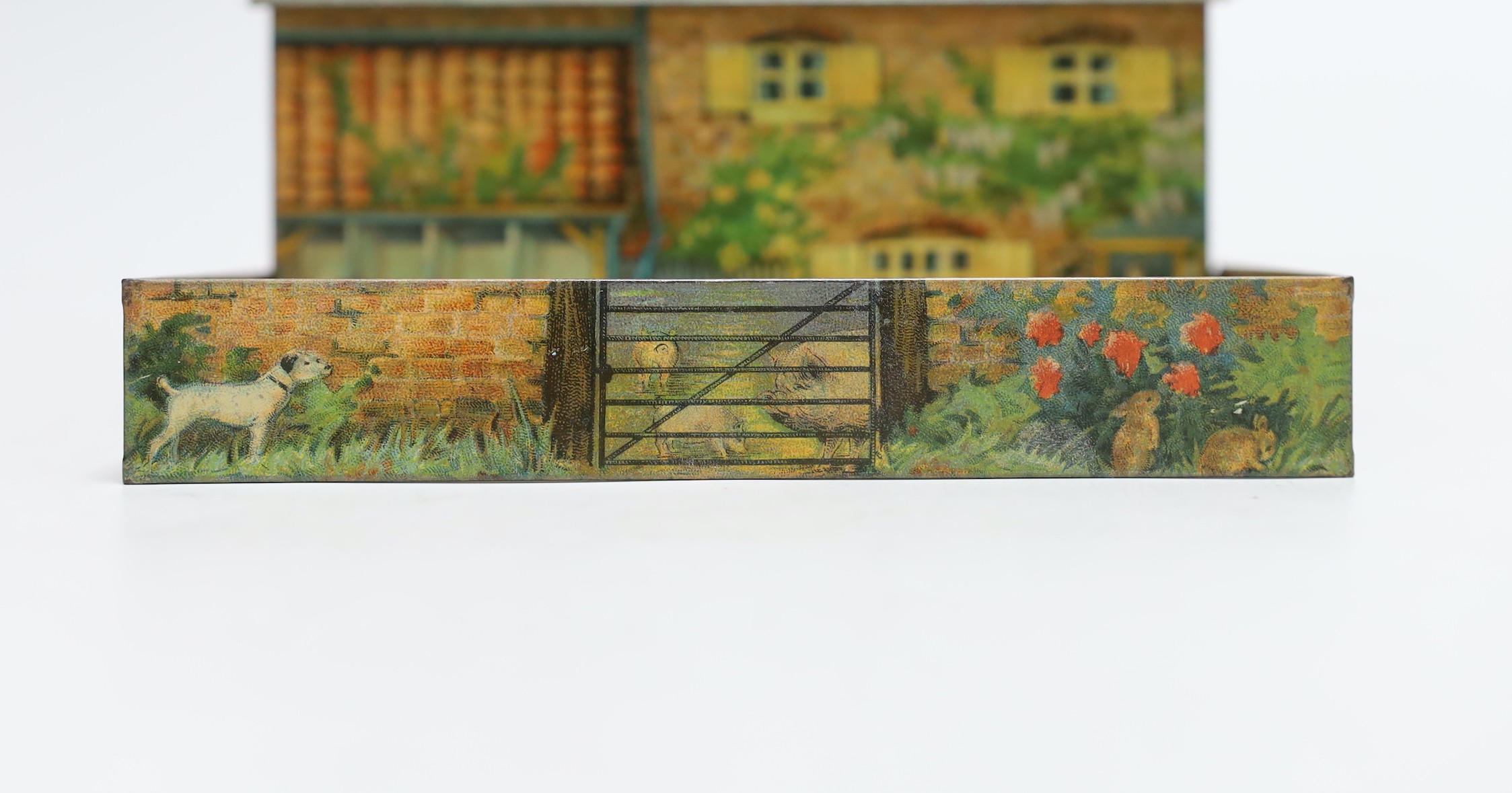 Britains farm series, a Schuco type monkey and a Huntley & Palmers novelty farmhouse biscuit tin, 16cm wide